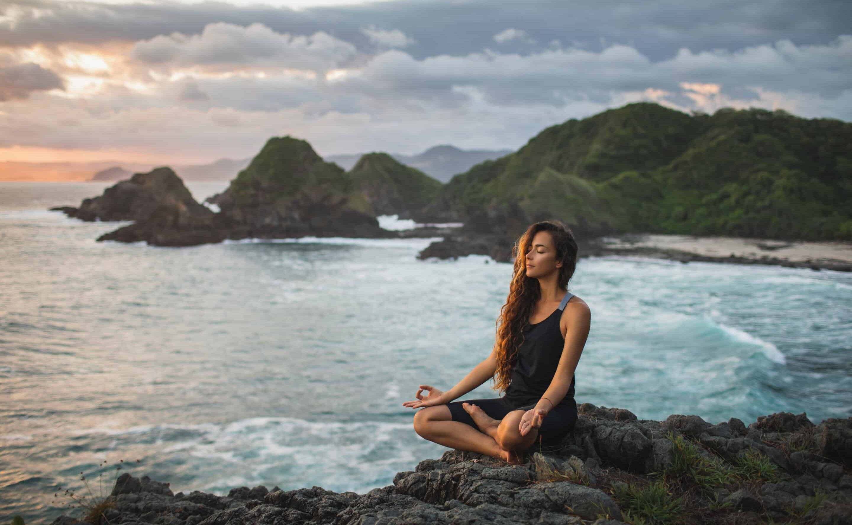 Woman meditating near ocean. Qigong Awareness - Tea With The Master Full Day Event. In person and Live Streaming.